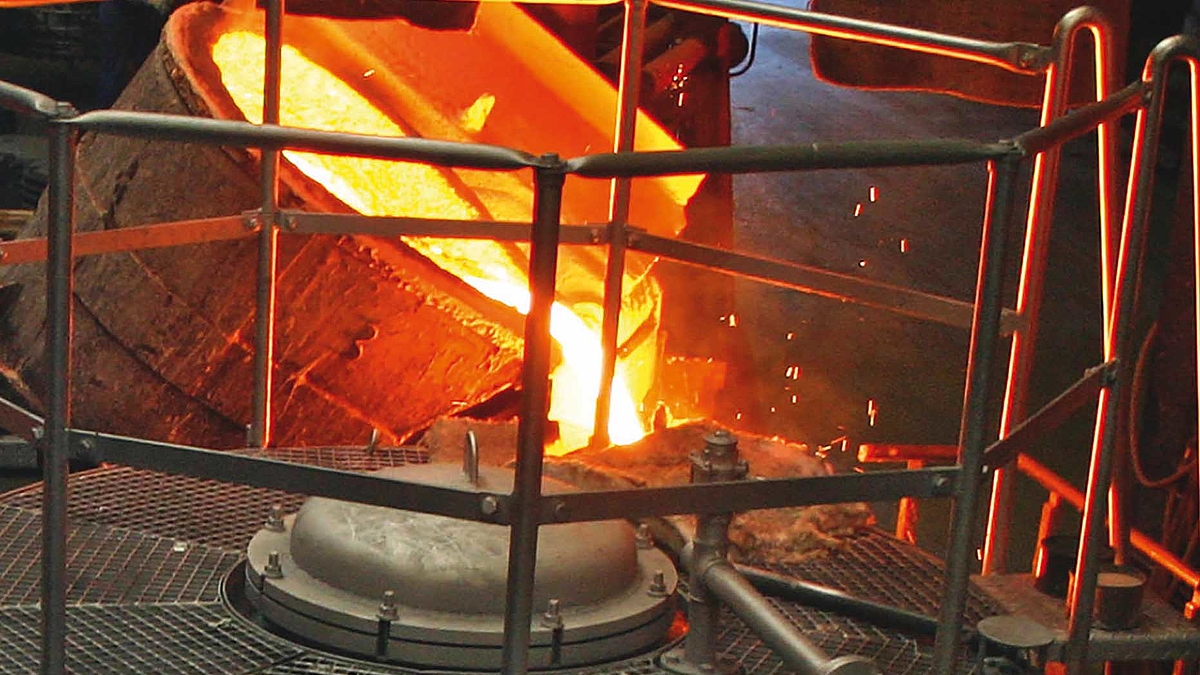 Flüssiges Metall wird nach dem Schmelzvorgang in einem Behälter abgegossen.